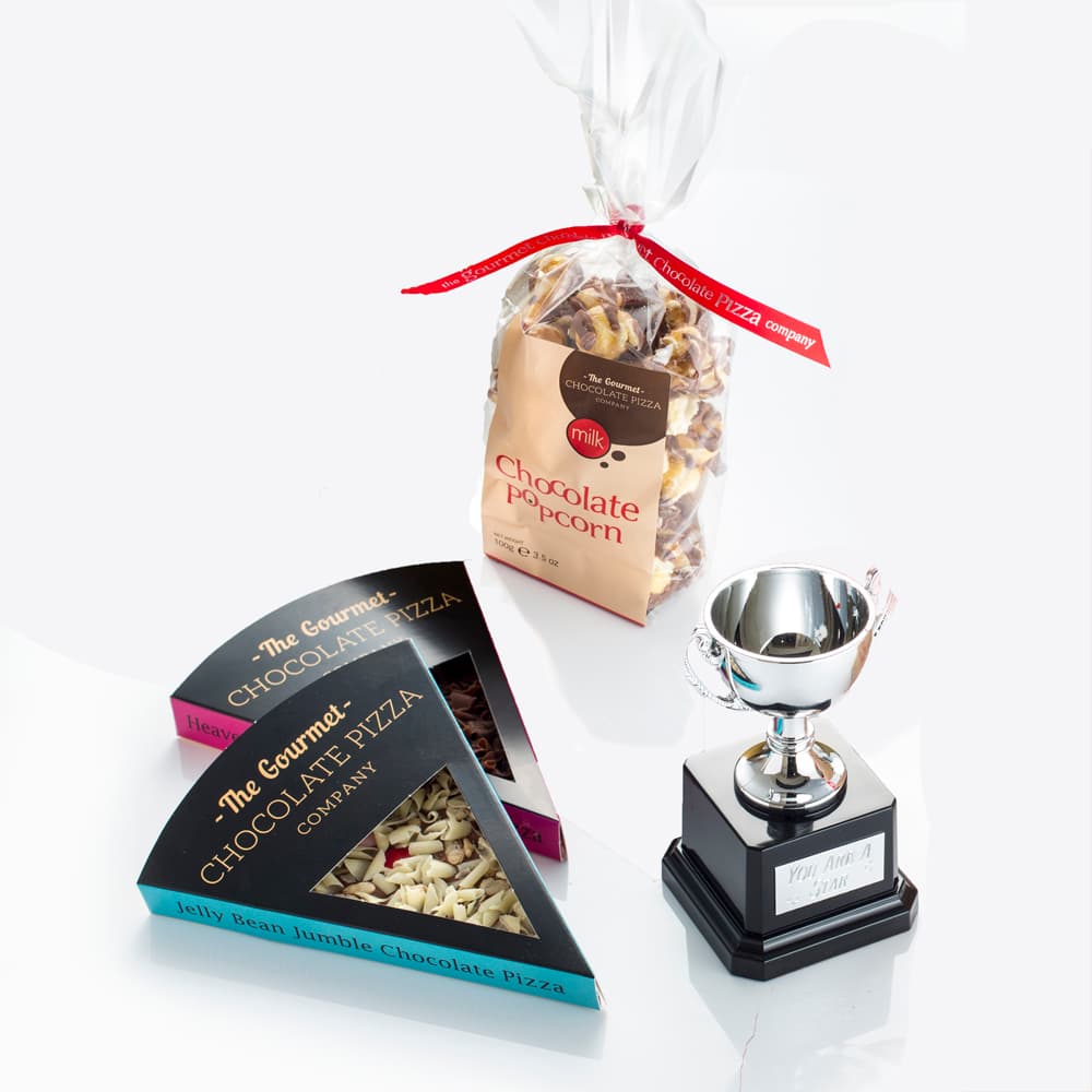 Hamper includes two of our best-selling chocolate pizza slices, a bag of Chocolate Drizzled Popcorn and trophy